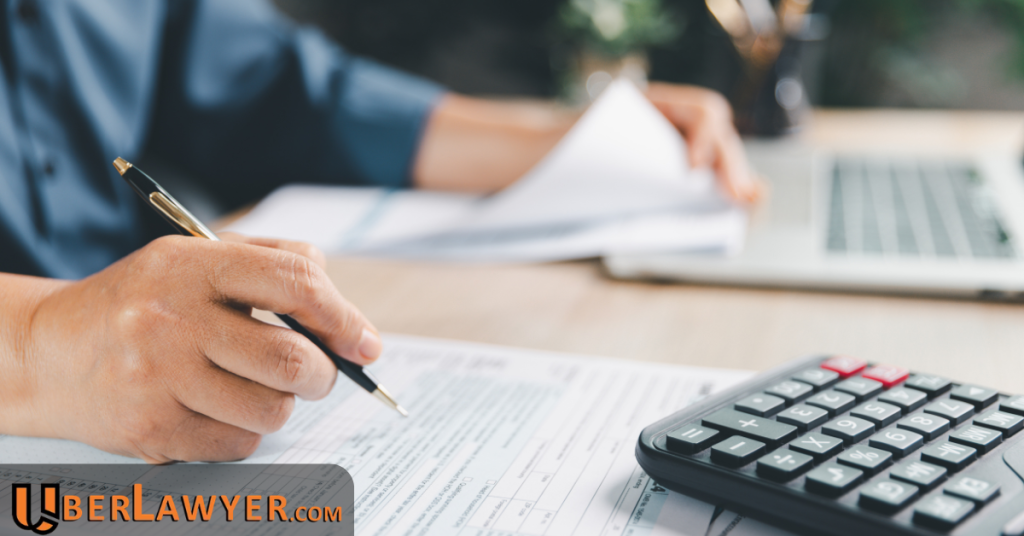 Person reviewing personal injury claim documents with a calculator to estimate compensation after an accident