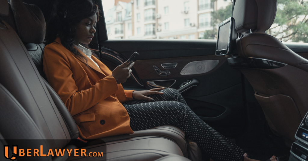 Rideshare passenger sitting in the back seat of a car using her phone during a trip