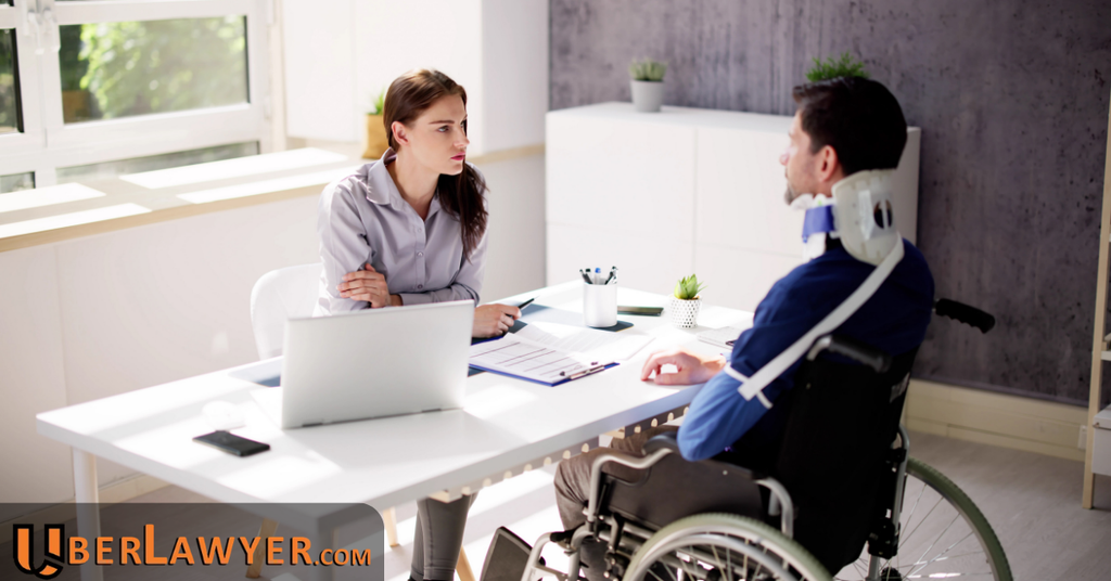 Injured man in a neck brace and wheelchair meeting with a lawyer at her desk